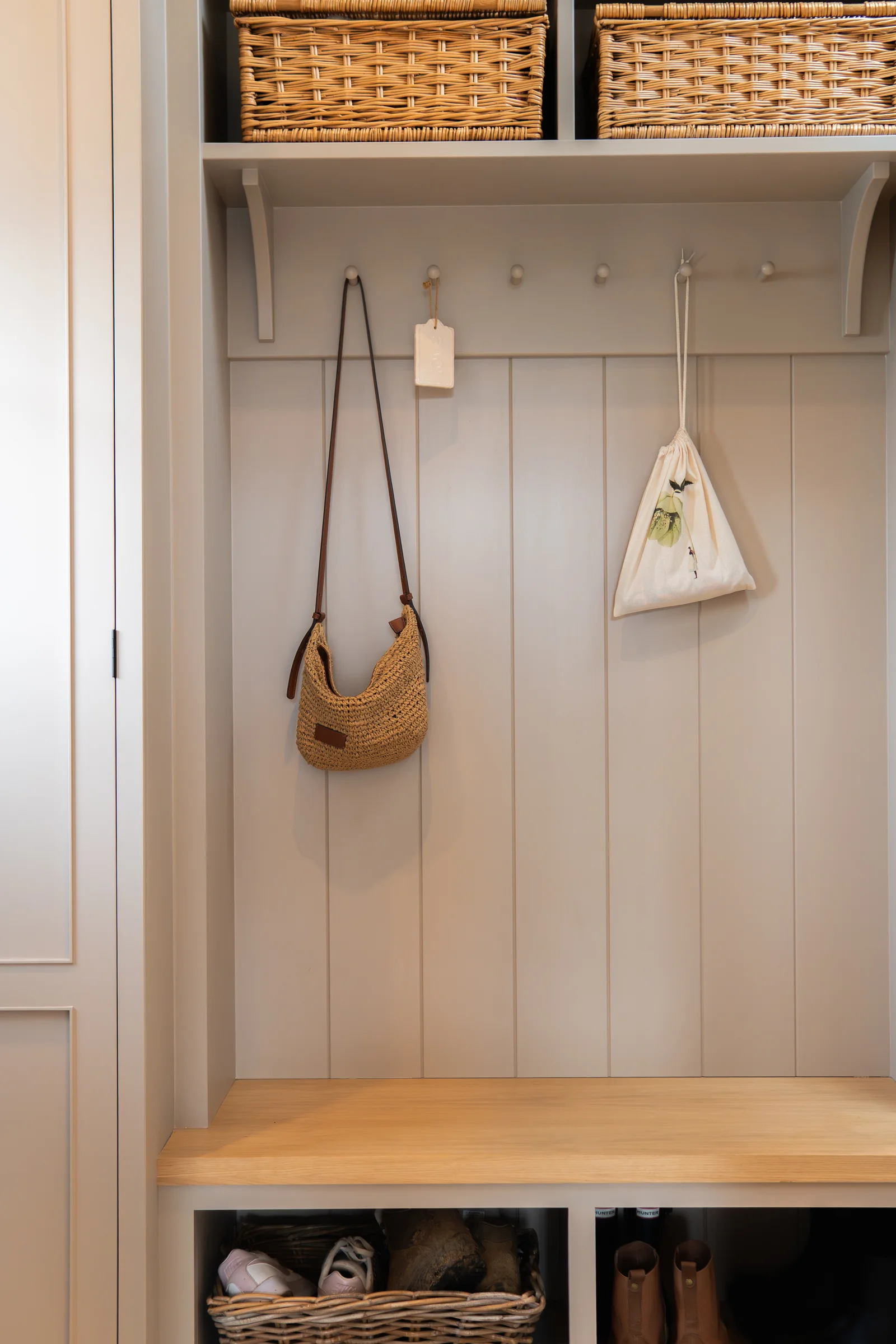 Boot room mudroom nook tongue groove panelling coat hooks wicker baskets oak bench shoes