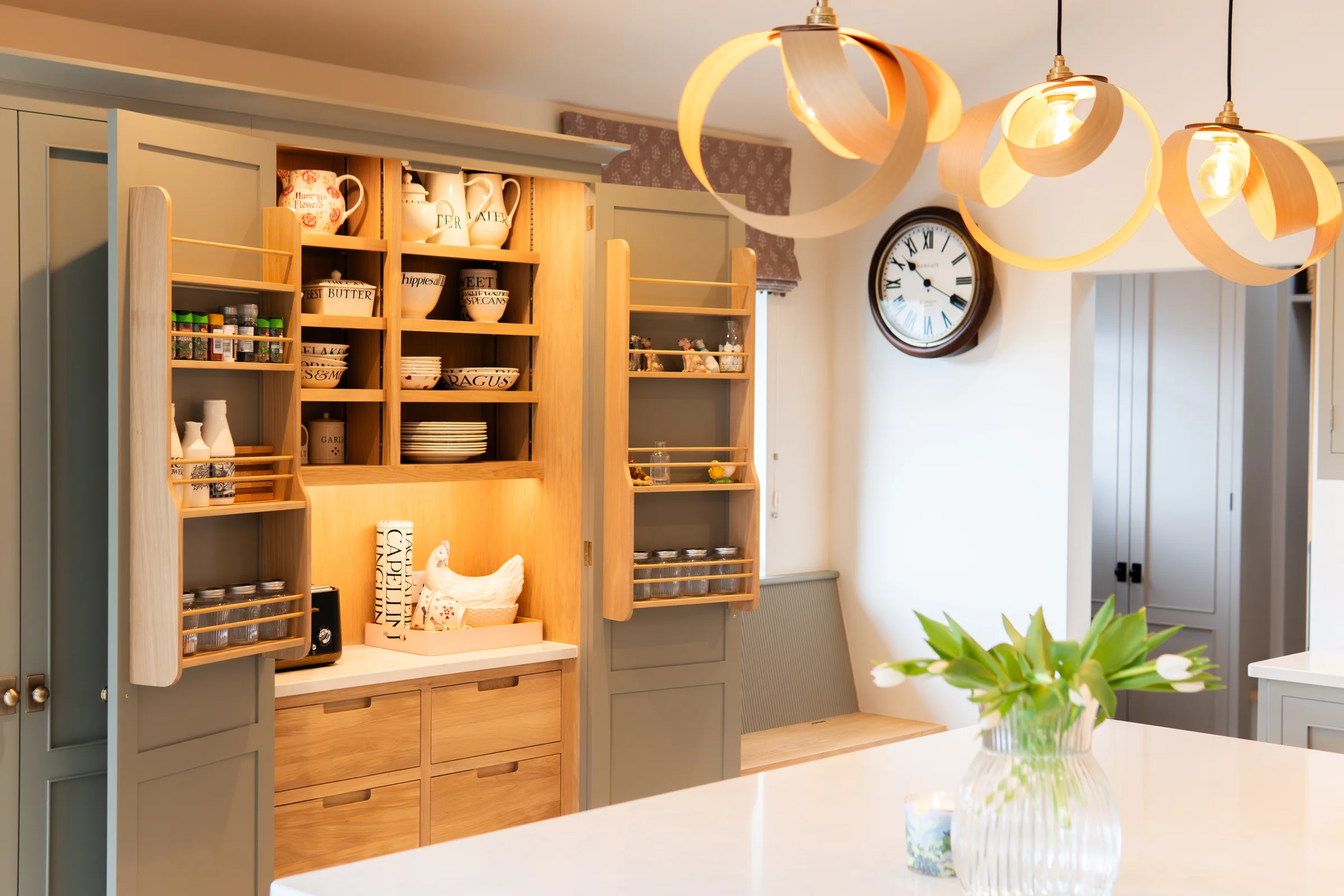Wide view pantry open wooden ribbon pendants white quartz island clock tulips