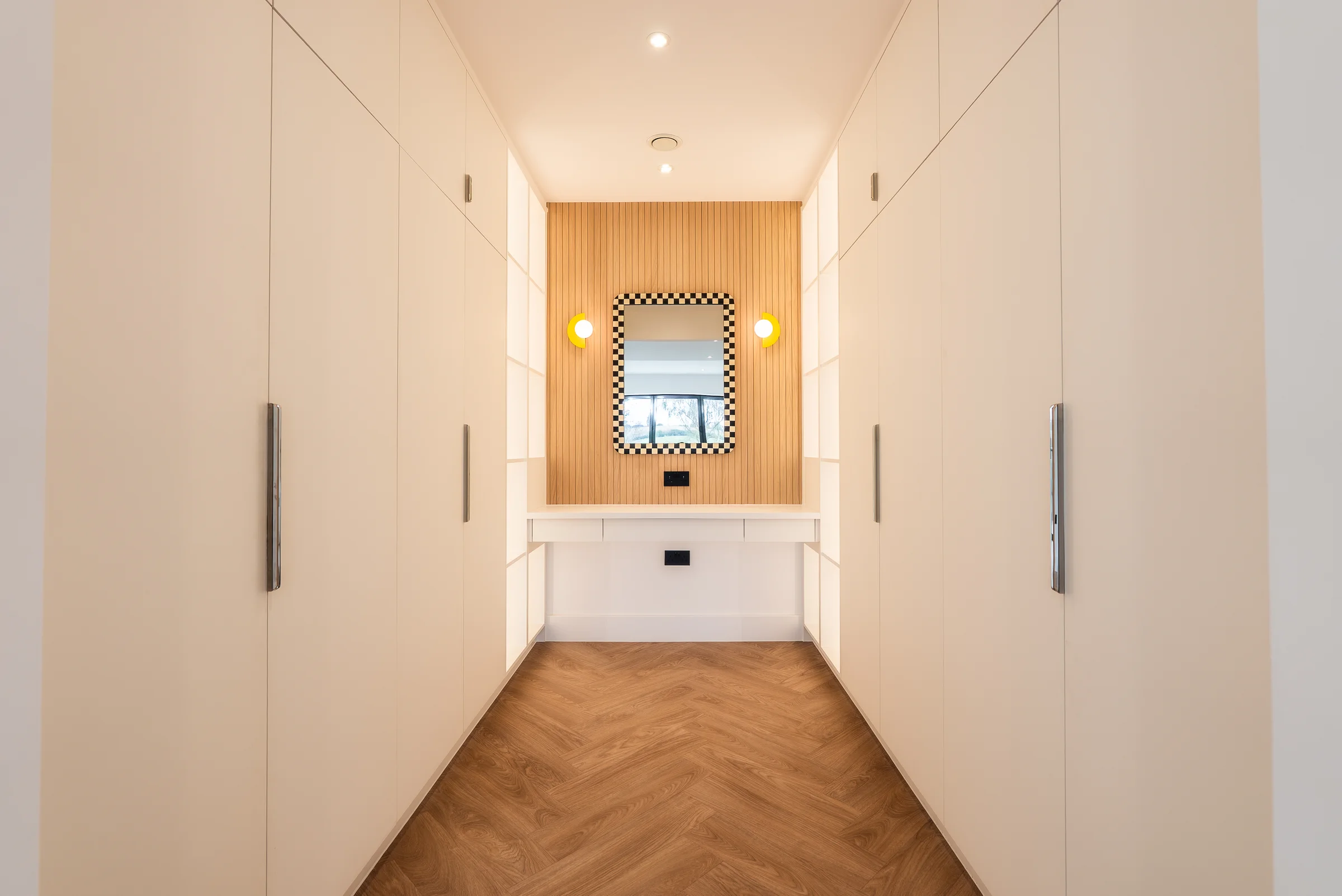 Dressing room white wardrobes chrome handles oak slat vanity chequerboard mirror globe lights