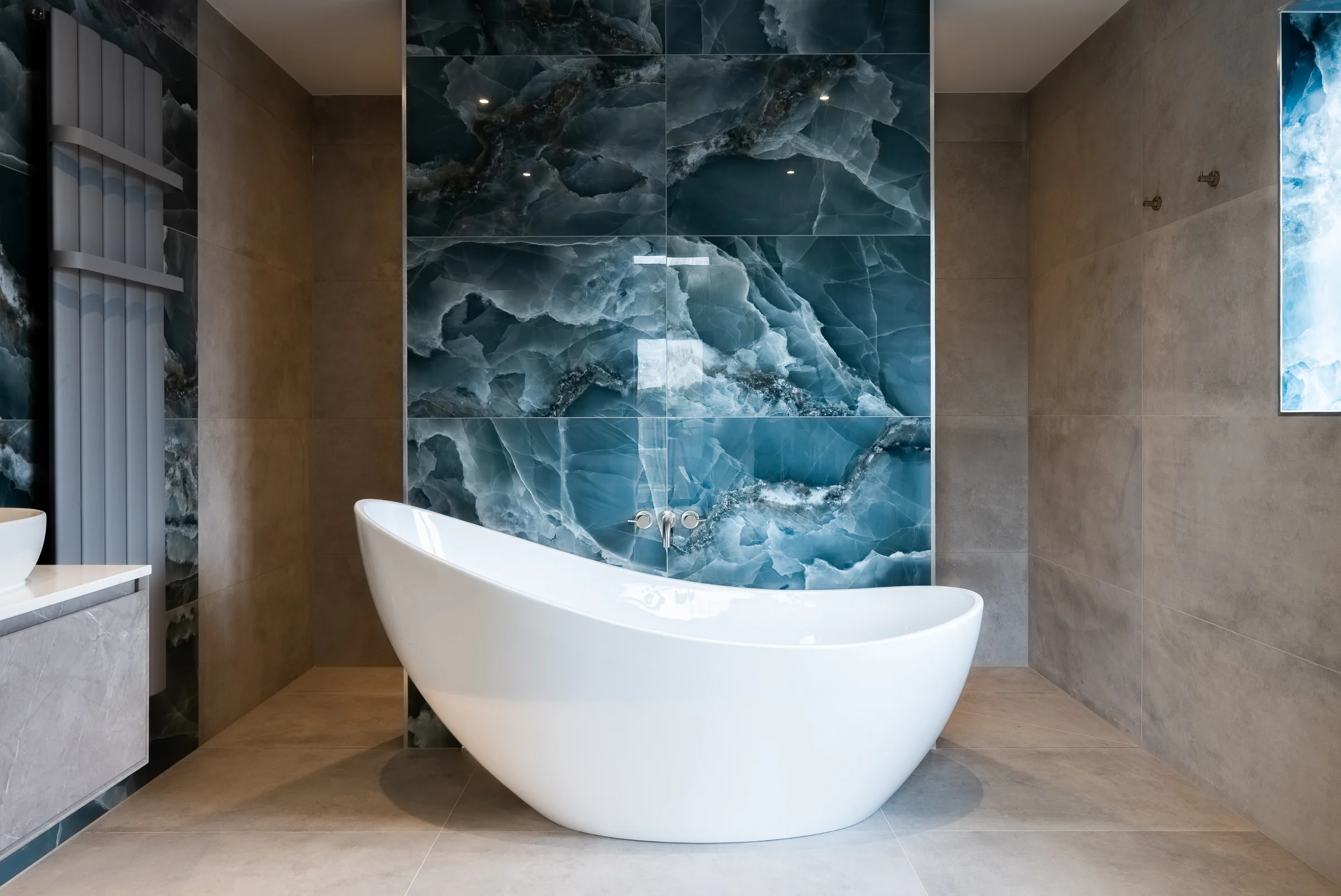 Luxury ensuite freestanding bath blue onyx feature wall wall mounted taps radiator