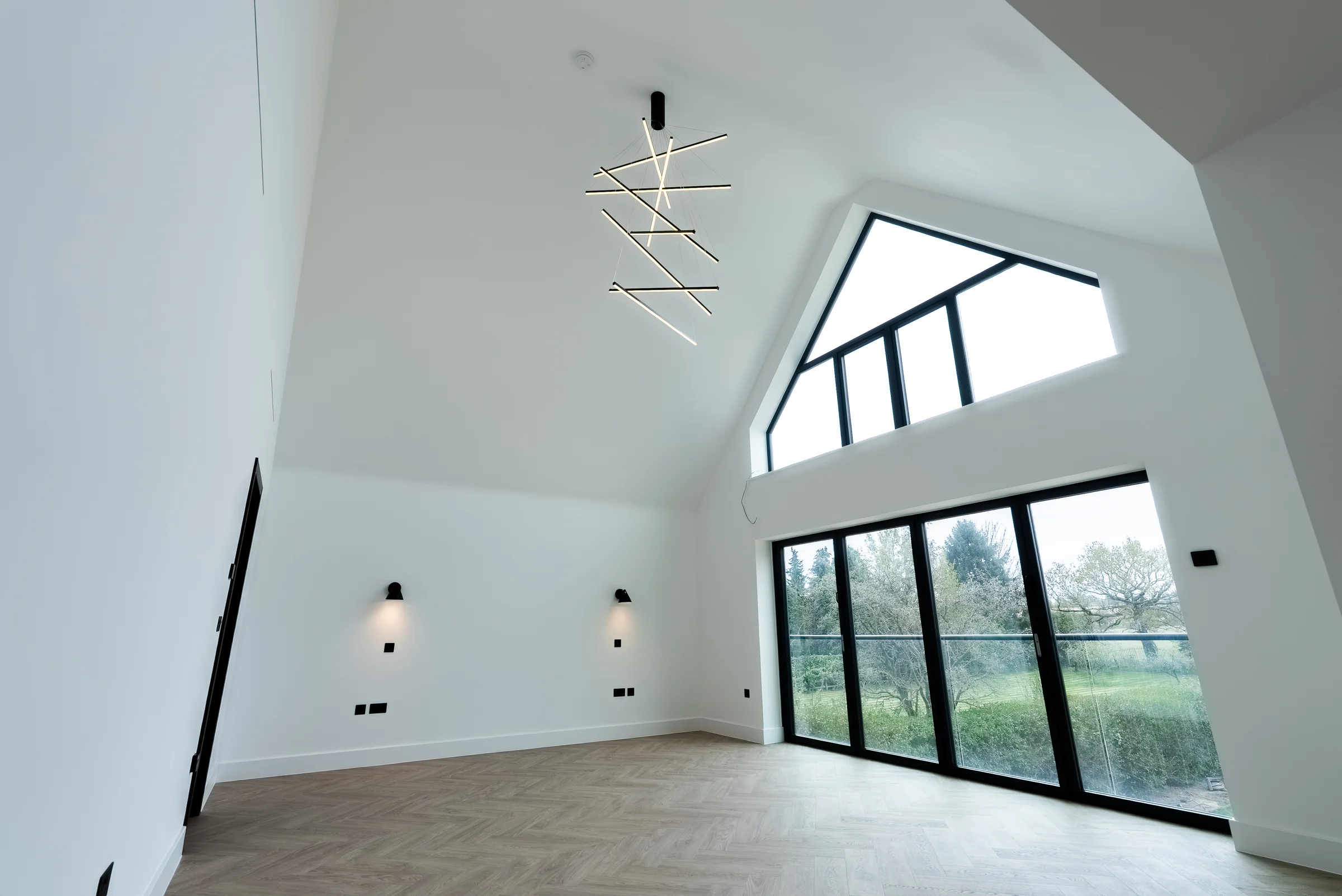 Master bedroom vaulted ceiling upward view geometric pendant gable window garden