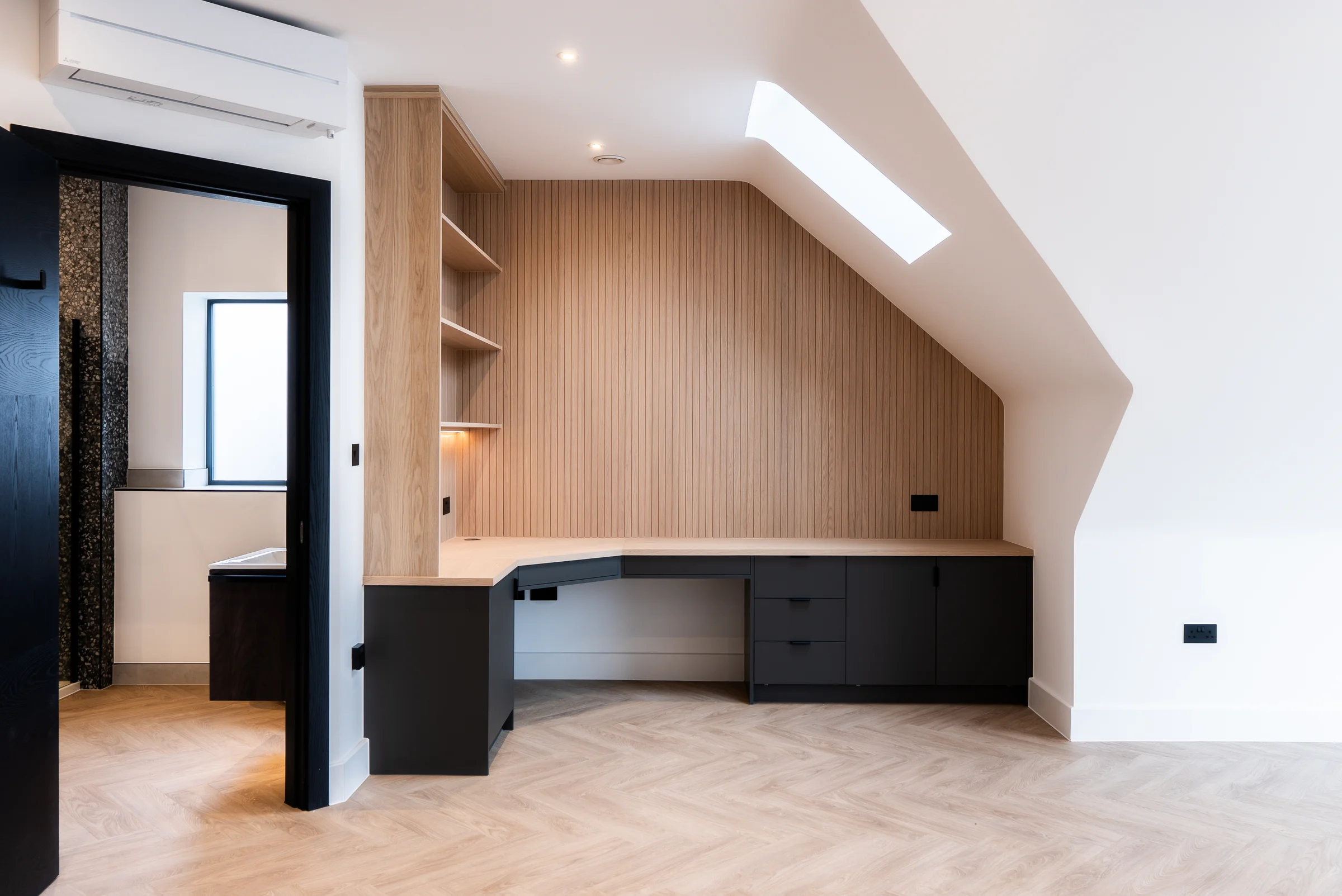 Oak slat desk closeup black drawers shelves skylight ensuite doorway