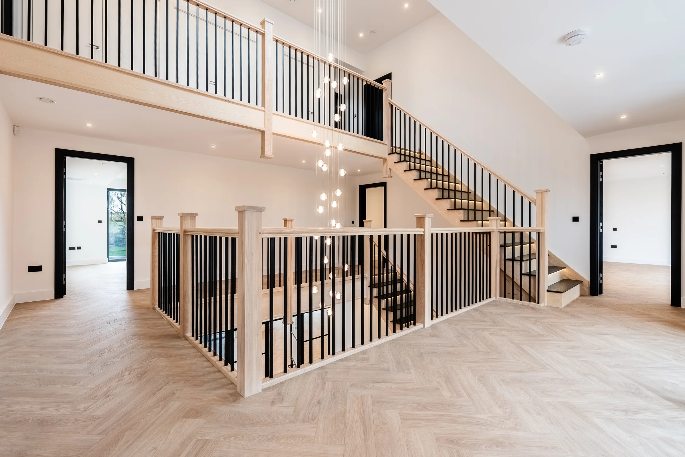 Oak staircase first floor landing black spindles glass chandelier black doors