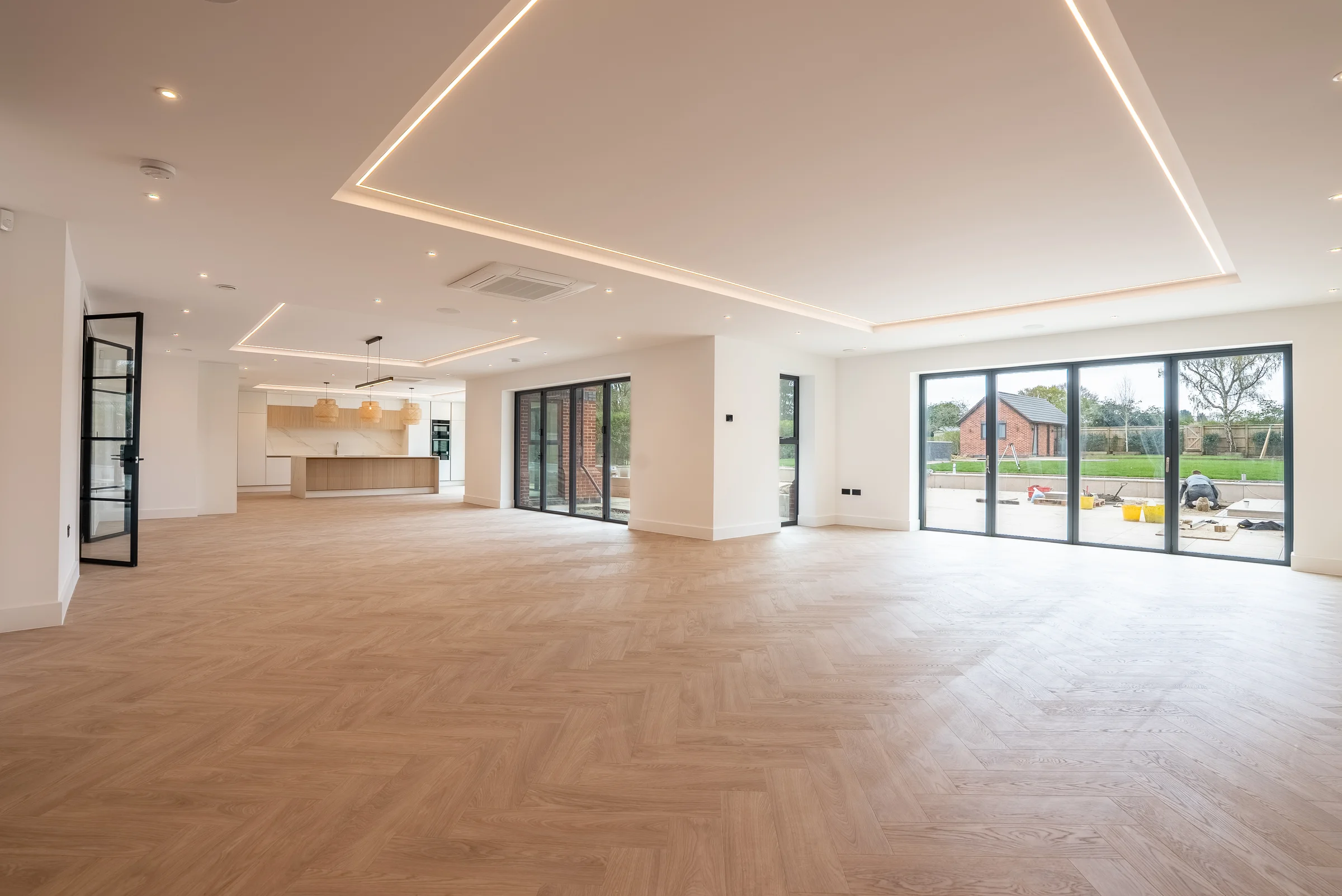 Open plan living kitchen led ceiling detail bifold doors garden herringbone