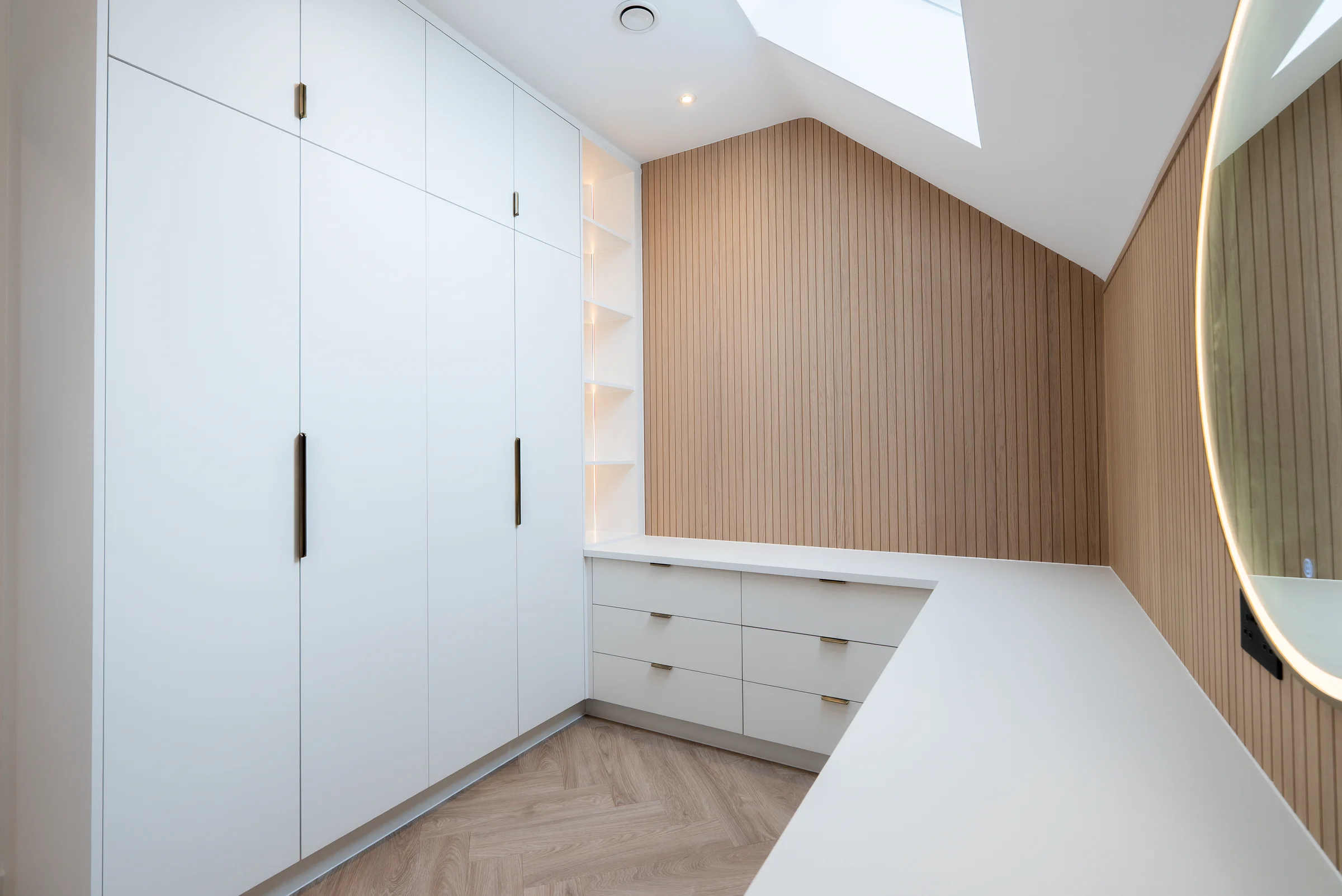White dressing room wardrobes oak slat wall vanity drawers lit mirror skylight