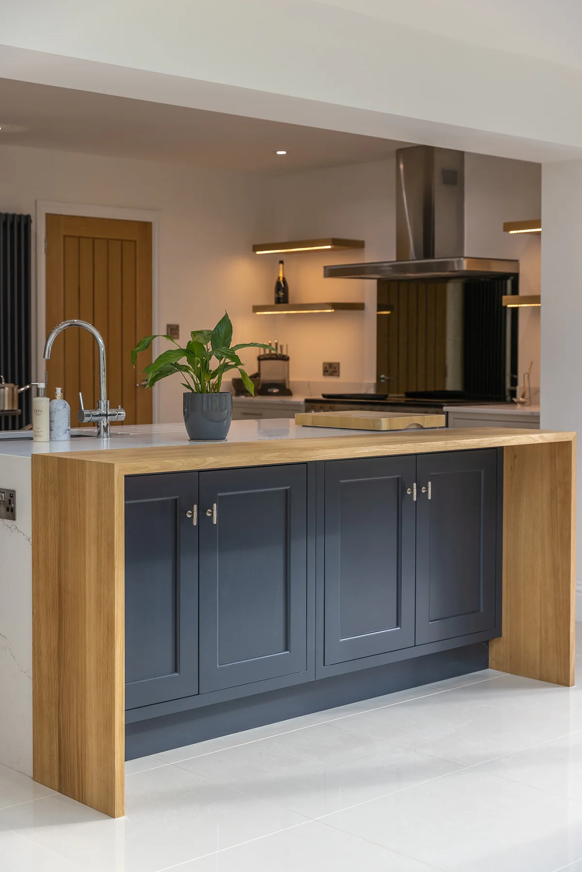 Dark blue shaker island closeup oak waterfall chrome handles quartz
