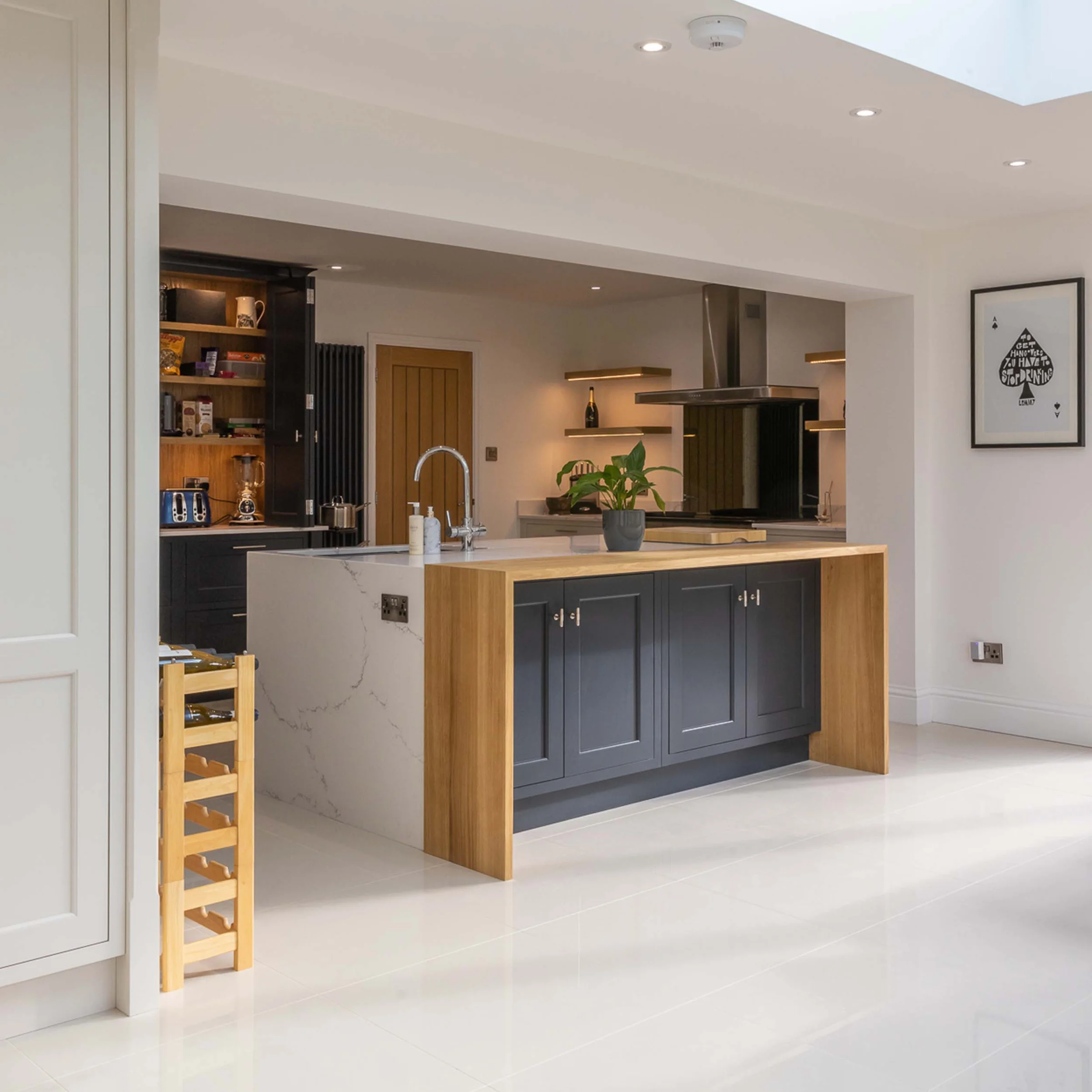 Dark blue shaker island oak waterfall end quartz worktop wine rack skylight