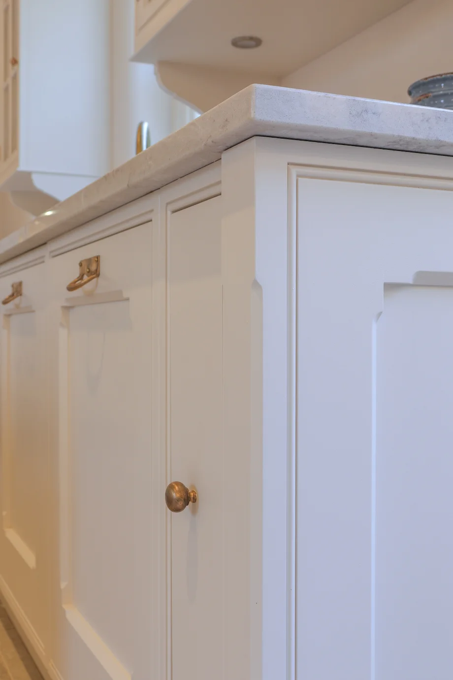 Cream shaker door brass knob closeup marble worktop edge