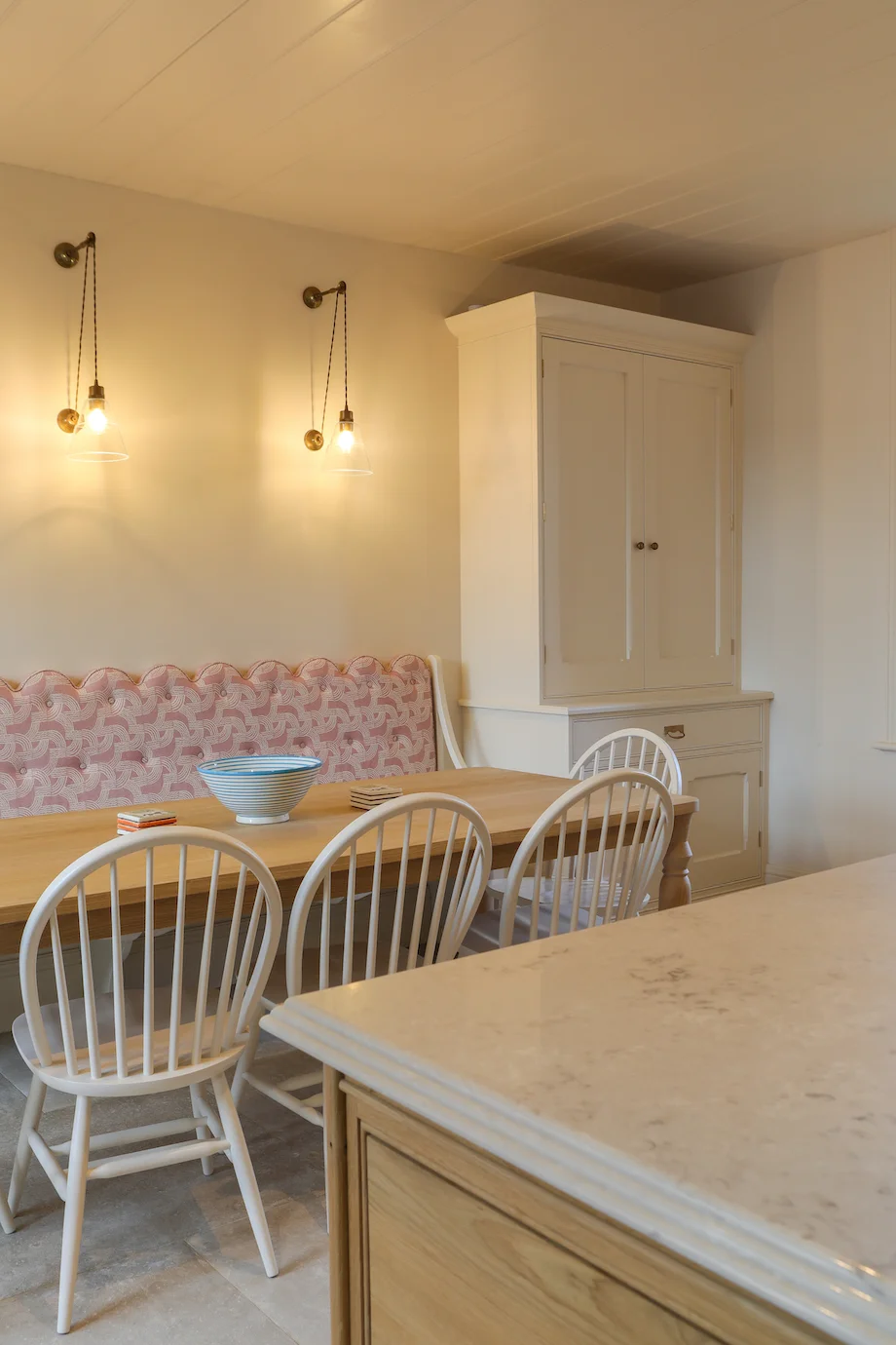 Dining banquette windsor chairs oak table cream larder brass wall lights
