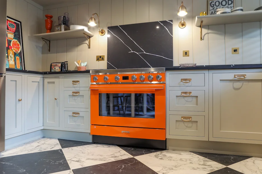 Wide angle orange smeg marble splashback brass wall lights chequerboard floor