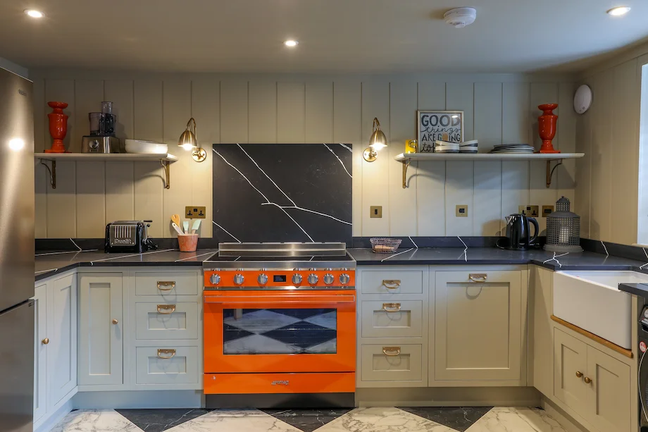 Wide view orange smeg grey shaker belfast sink open shelves panelling chequerboard