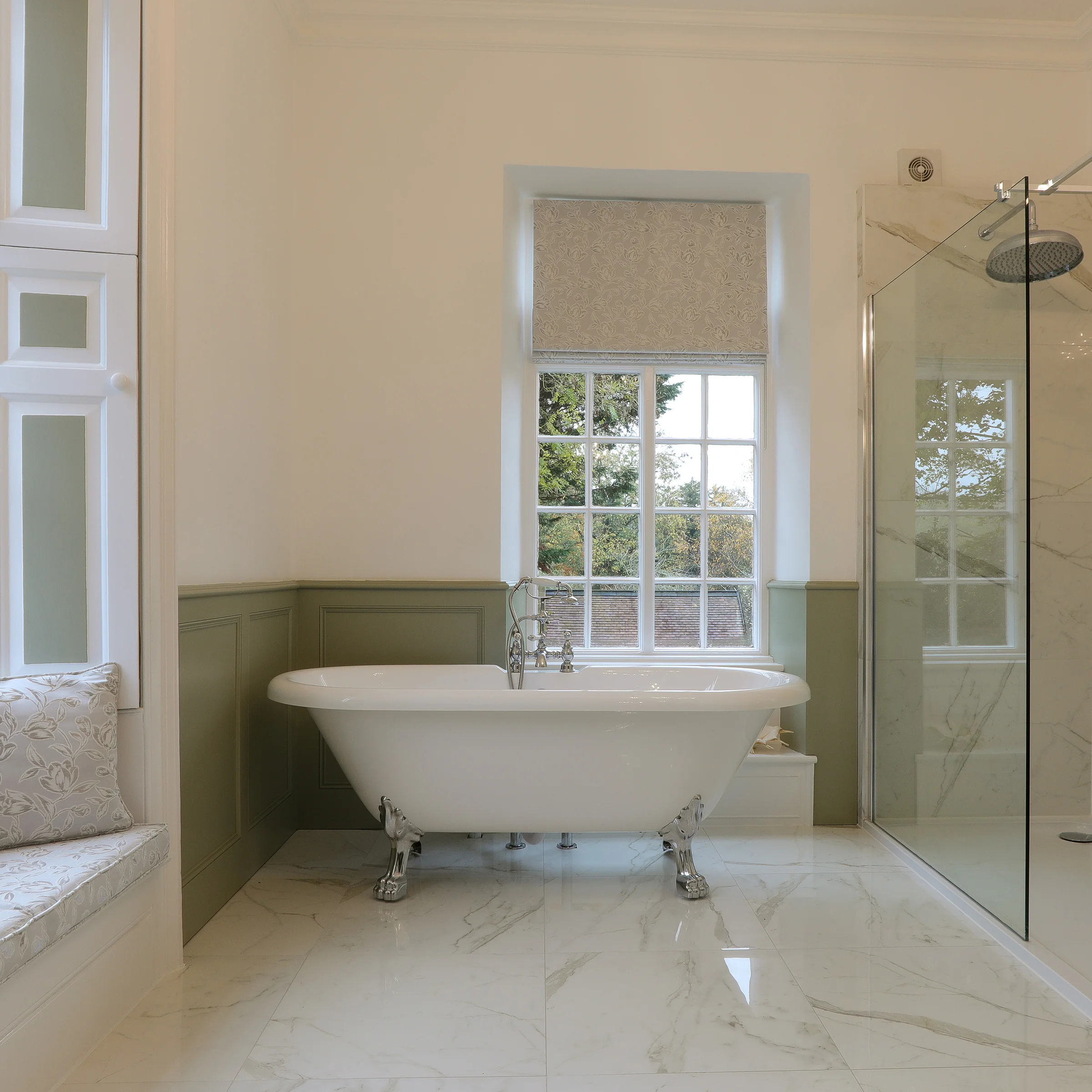 Freestanding roll top bath sage green panelling marble floor glass shower sash window
