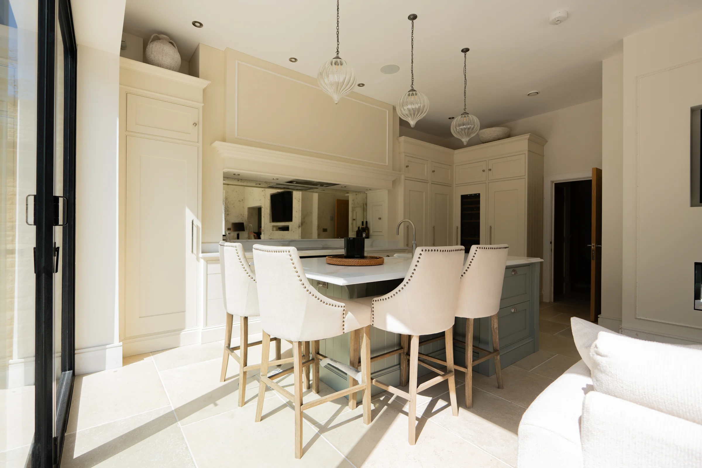 Wide from living four bar stools sage island glass pendants cream cabinetry crittall