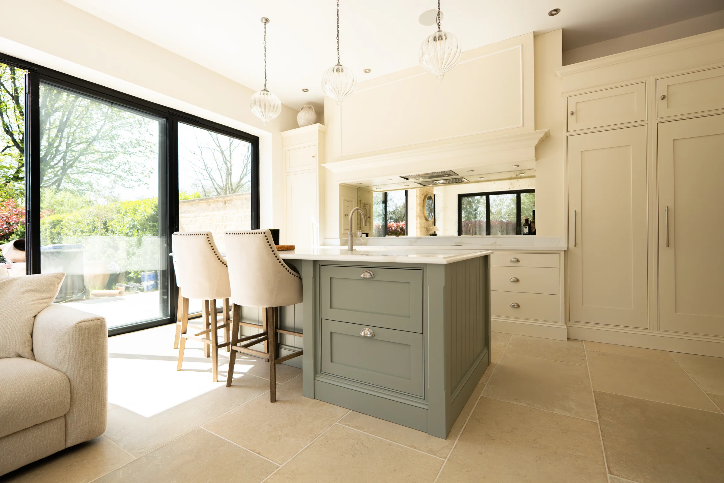 Full kitchen sage island cream units antiqued mirror glass pendants crittall doors limestone