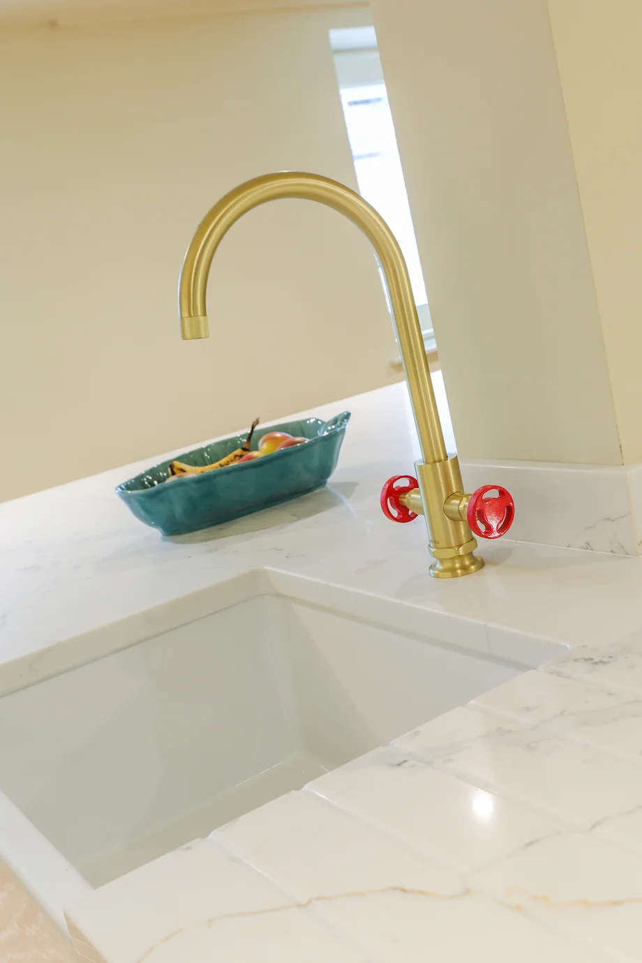 Brass tap red wheel handles closeup quartz worktop belfast sink detail