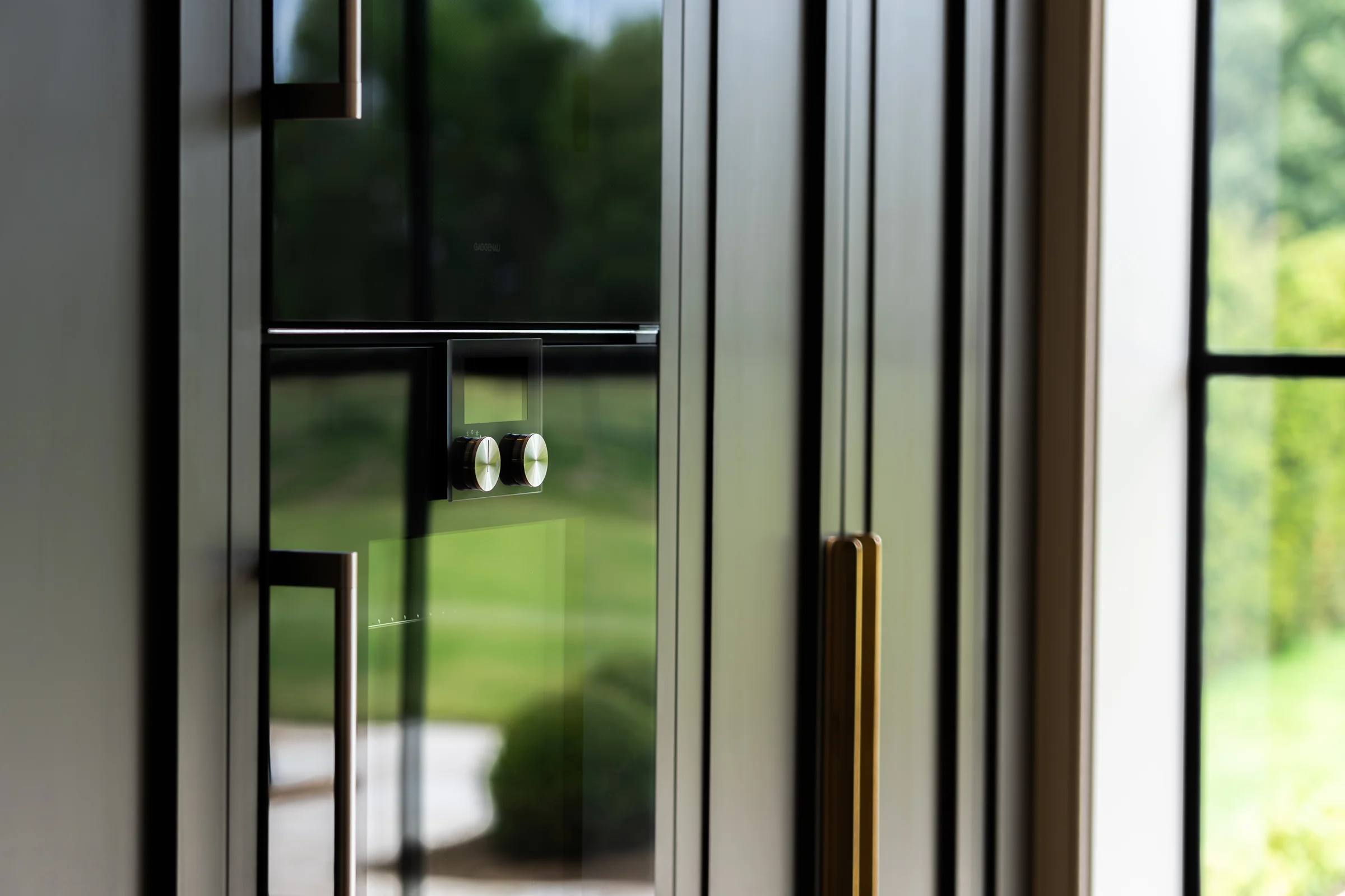 Artistic shallow dof built in oven window reflection cream units brass handle