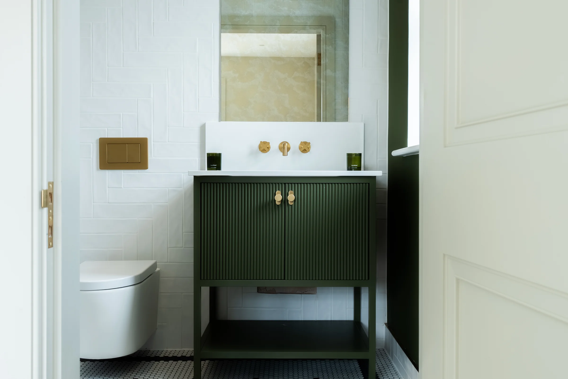 Cloakroom green reeded small vanity brass knobs taps mirror herringbone tiles toilet