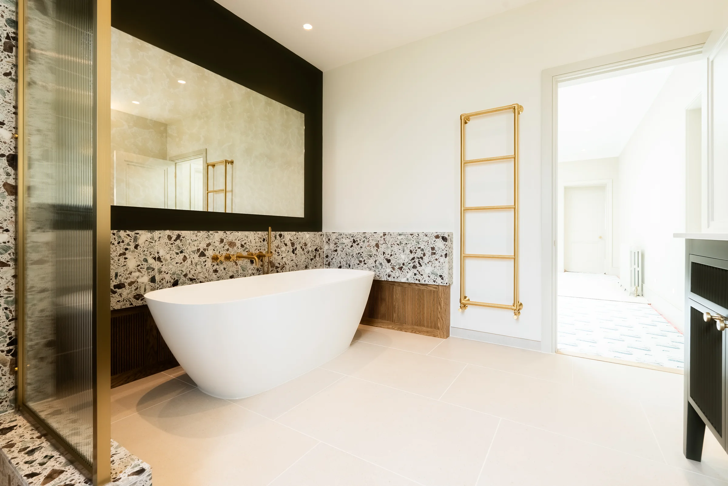 Ensuite bath opposite angle terrazzo brass towel rail dark vanity edge