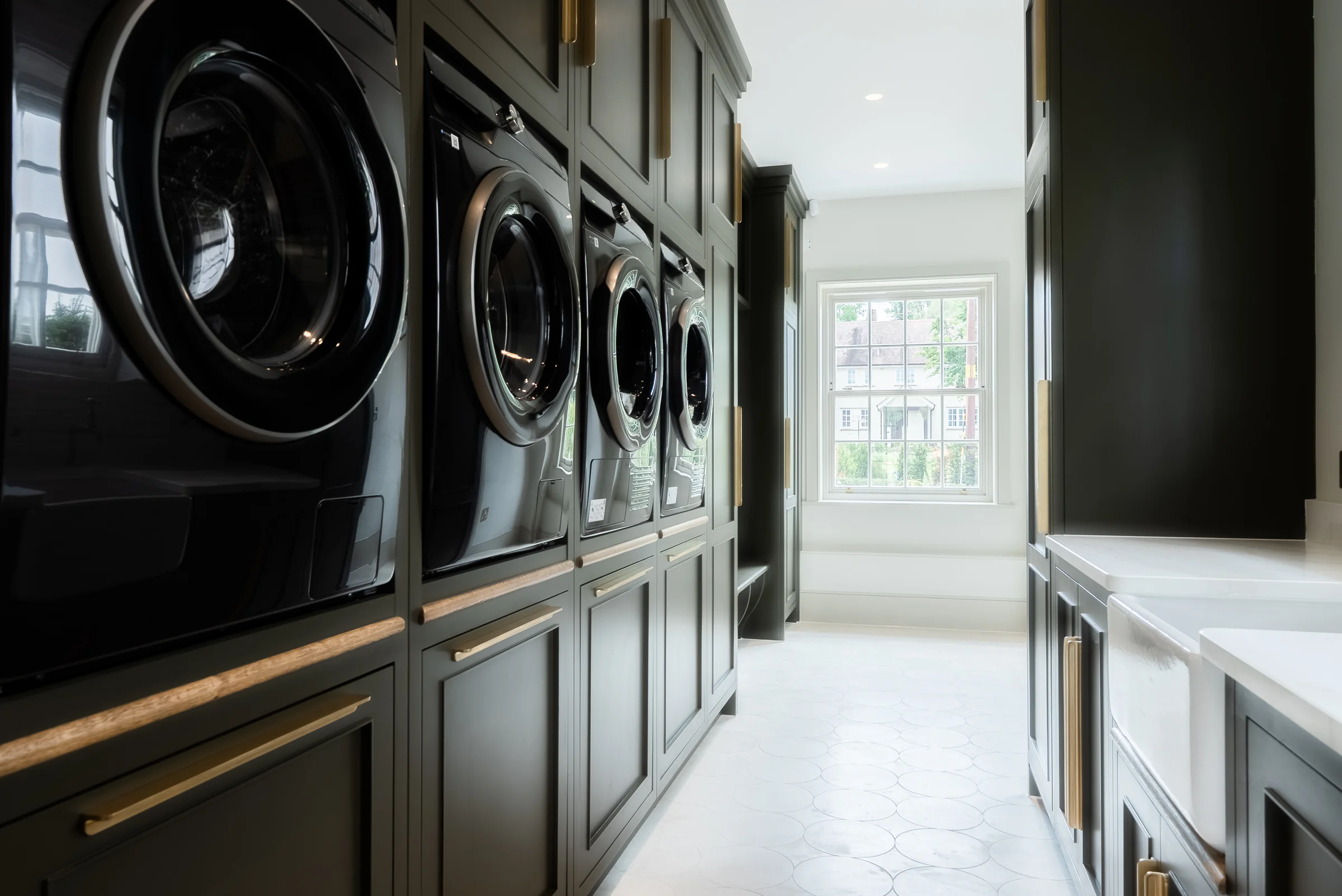 Luxury utility laundry dark charcoal units stacked machines brass handles marble floor belfast