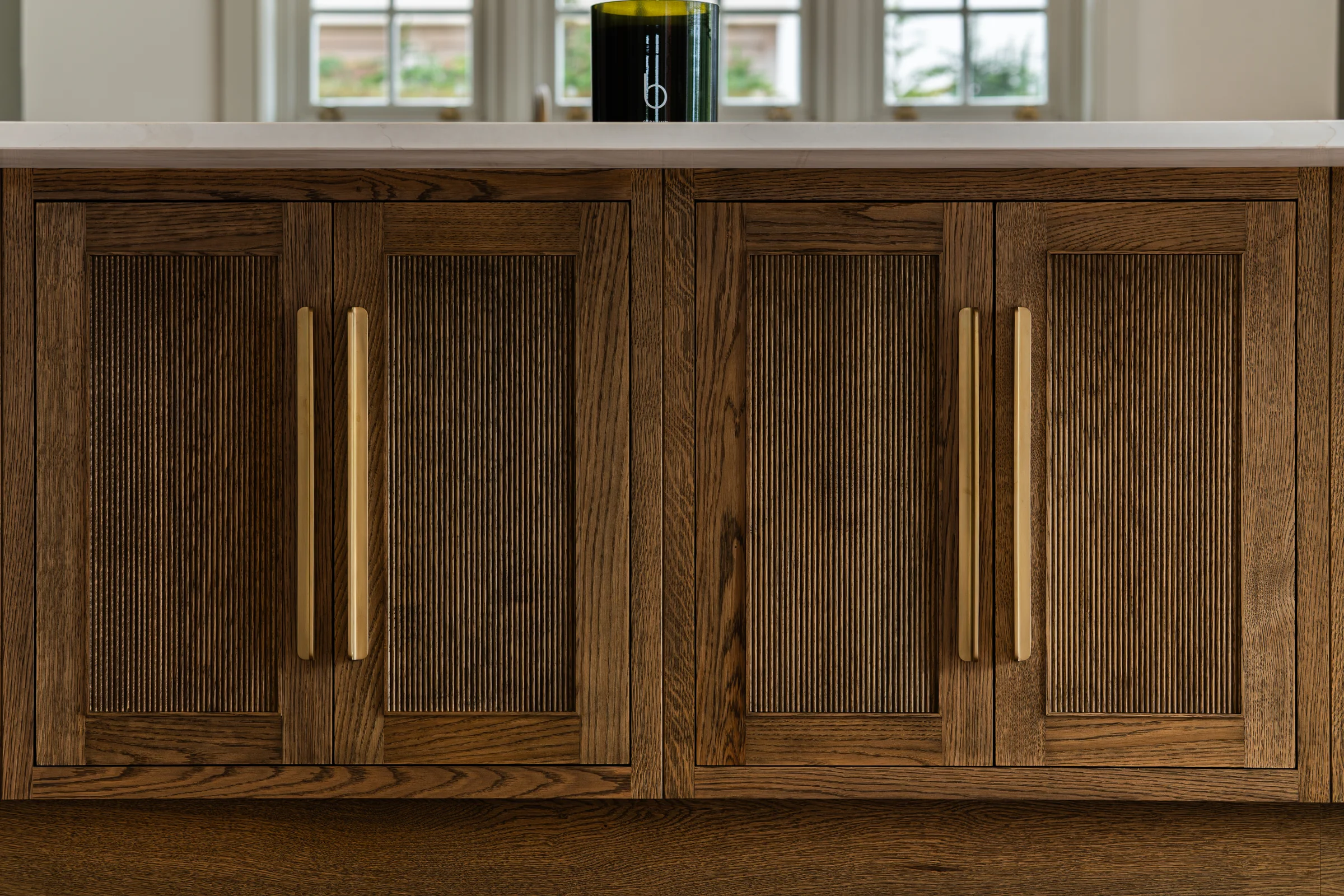 Oak island end reeded glass doors dark oak frames brass handles quartz