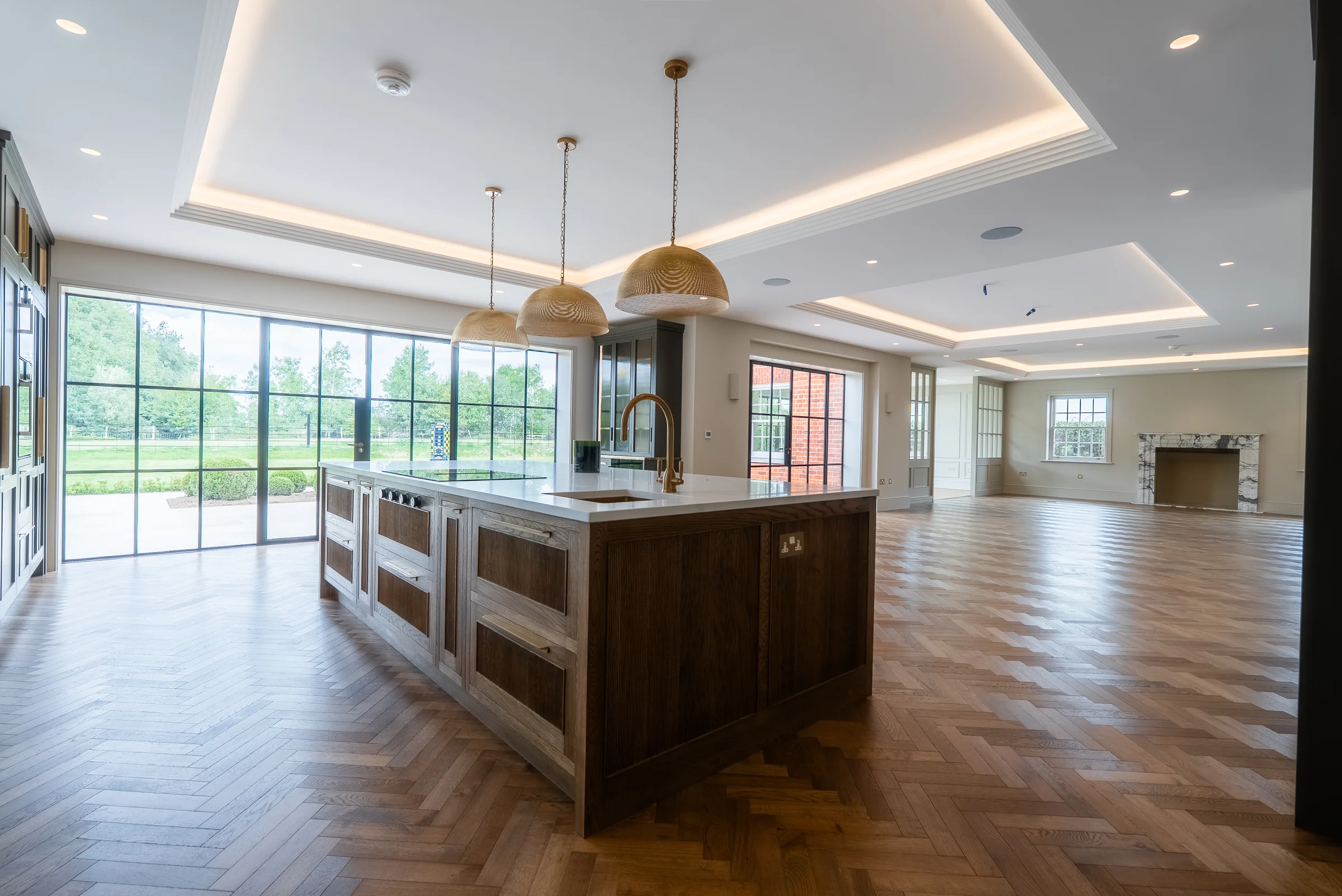 Open plan kitchen living oak island pendants crittall glazing marble fireplace coffered