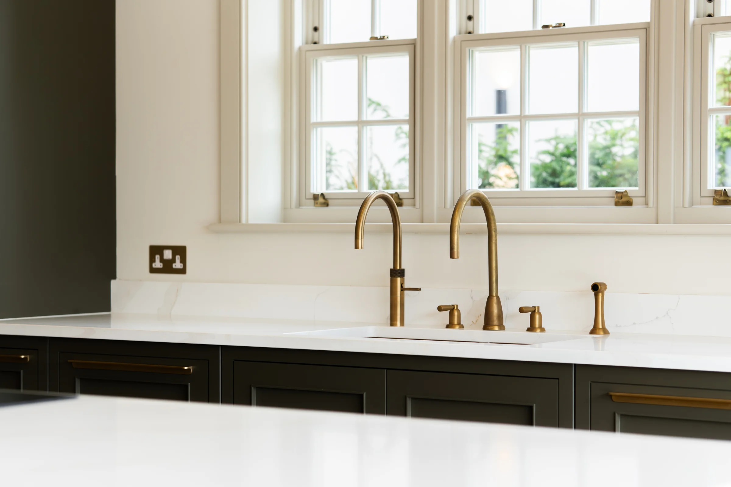 Sink area dual brass taps undermount sink marble quartz dark charcoal drawers