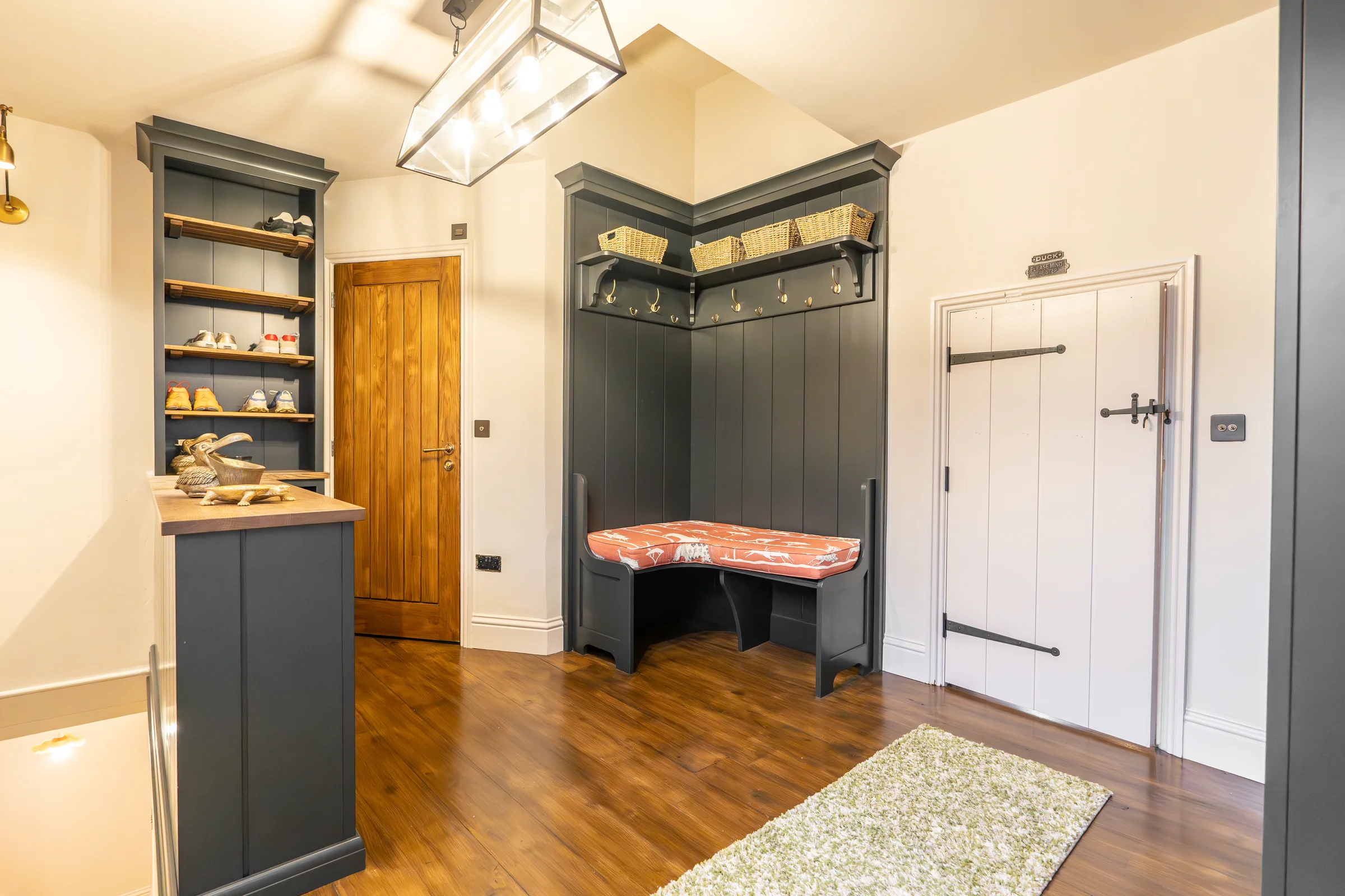 Boot room charcoal bench seat orange cushion coat hooks baskets lantern pendant brass lights