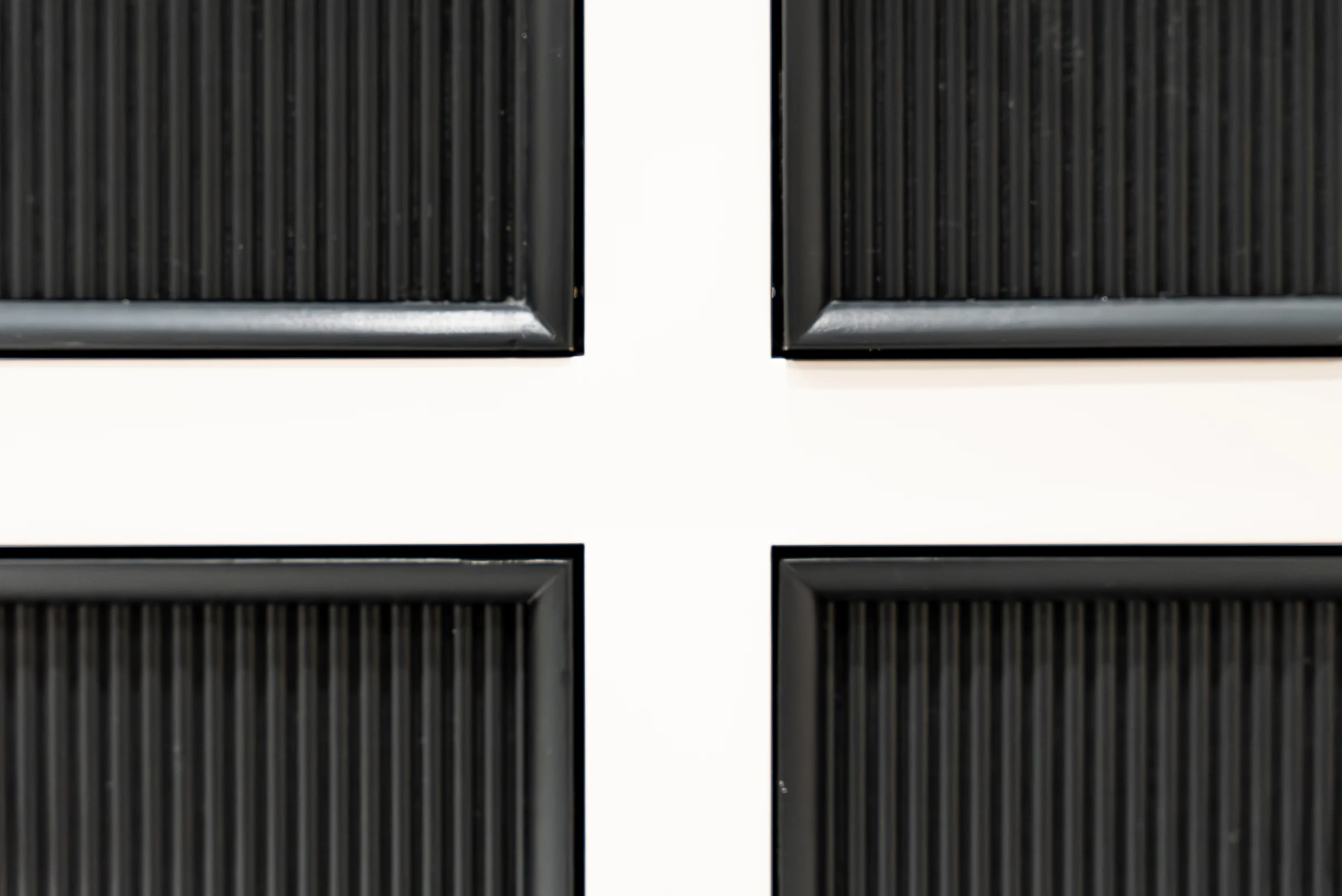 Closeup navy reeded drawer fronts white frame four drawer grid detail