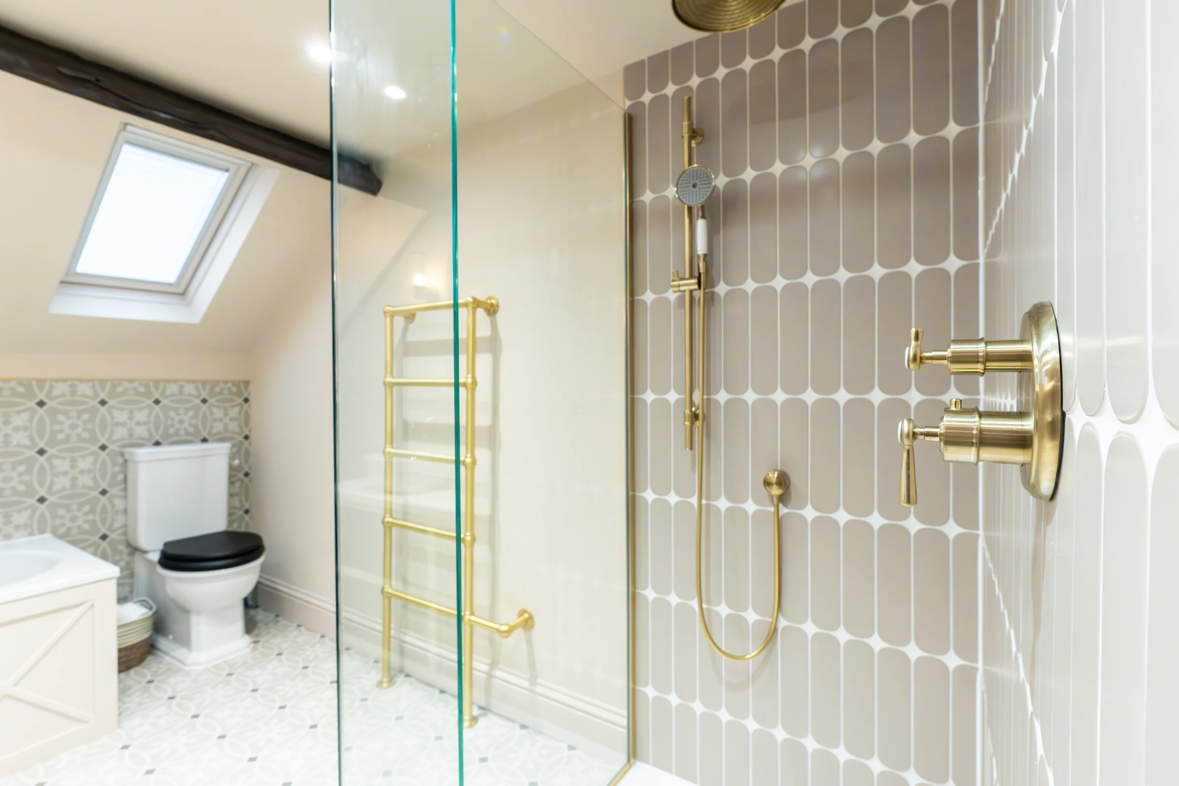 Ensuite shower closeup taupe scallop tiles brass rain head fittings towel rail skylight