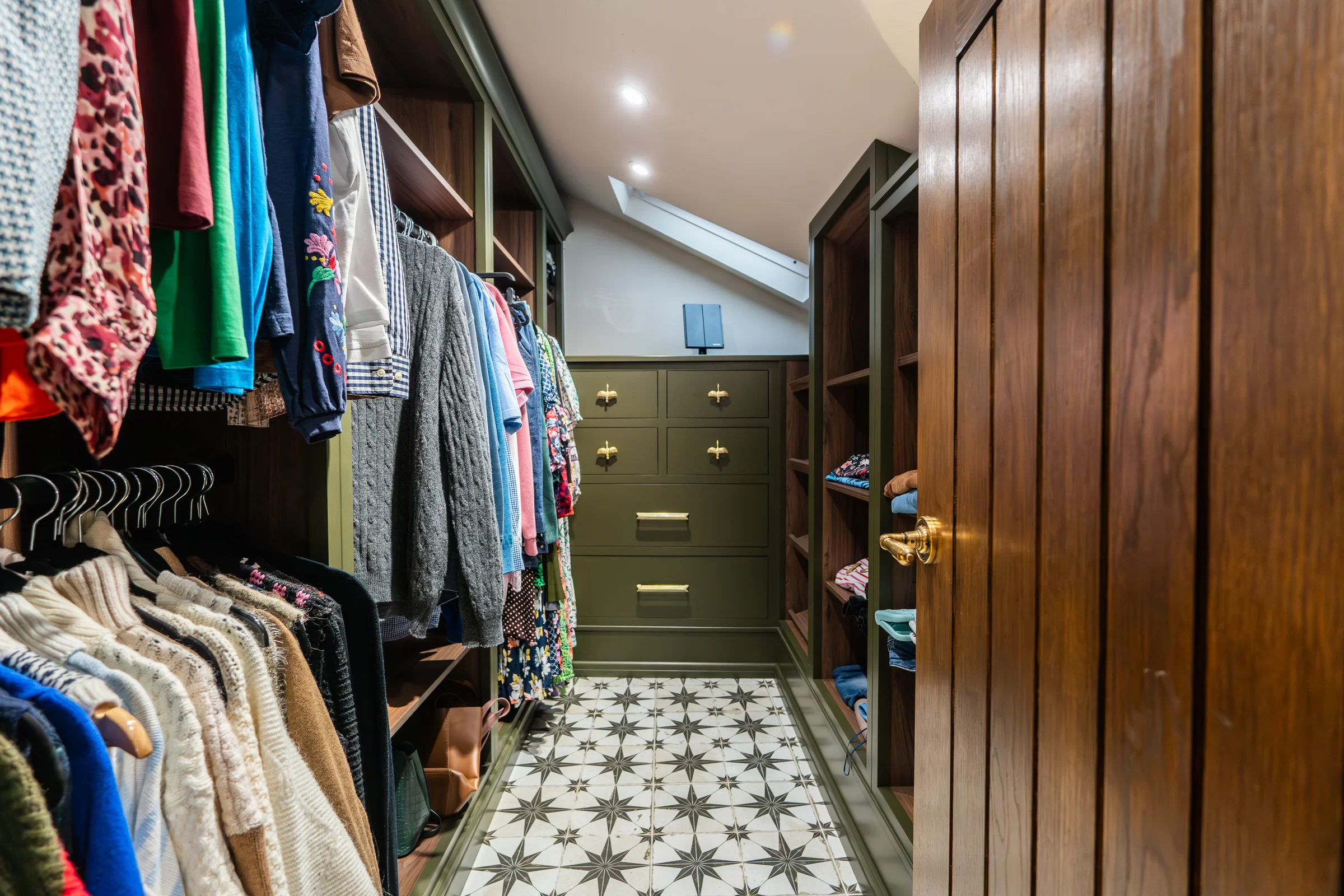 Walk in wardrobe olive green drawers brass handles hanging rails star tiles walnut door